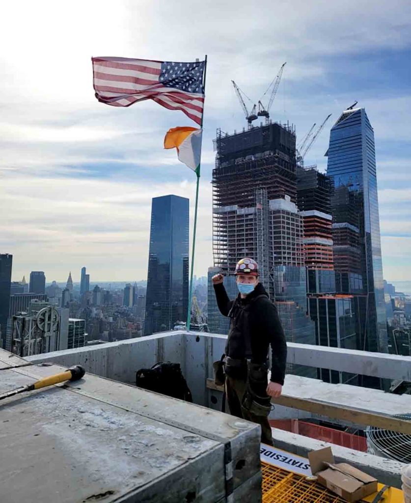 Surveying building in NYC with American Flag